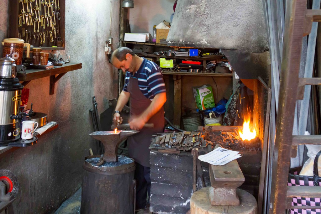 Blacksmith making large nails for wooden doors.